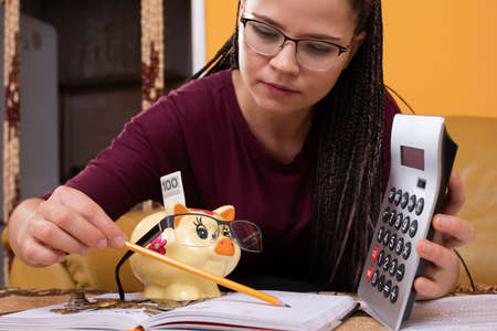 The teacher is satisfied with her student - a moneybox, who mastered all the material related to accounting and accounting for household budget bills in a short time.の写真素材