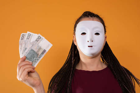 Paper notes held in a hand. A young adult holds up cash with her fingers. Hands stretched out in...