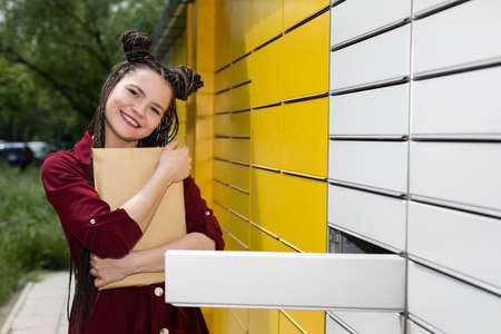 Smiling teenage girl. Great joy from the received parcel. African braids.