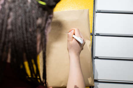 He mentally searches for the exact correspondence address. He writes with a white pen on an...