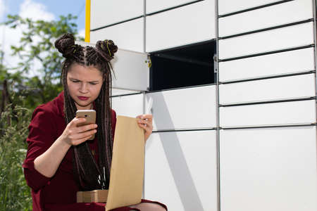 After opening the mailbox and taking out all the parcels, the girl carefully checks all senders.