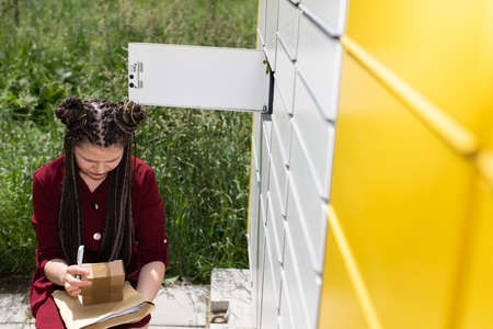 After opening the mailbox and taking out all the parcels, the girl carefully checks all senders.