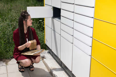 He carefully checks the opened mailbox. Young teenage girl with an interesting hairstyle. African...