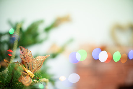 Festive decoration for choice. Golden decorative butterfly on the Christmas tree. Christmas tree lights in the background. Christmas decorations.の写真素材