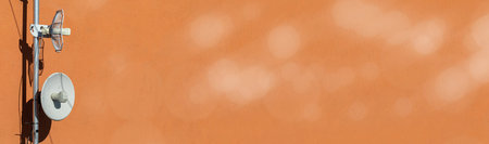 Wireless internet and mobile telephony transmitting and receiving antennas mounted on the building wall. Technology of digital sending and receiving of data packets. Panoramic view. Bokeh effect.の写真素材