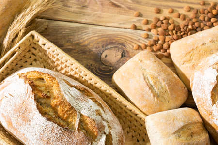 An old wooden shop counter with an appetizing decoration made of bread, rye scythes and peach seeds....