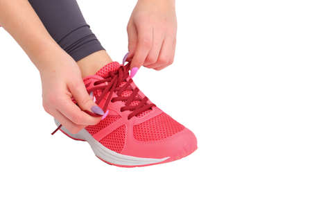 Before gymnastics, the girl ties her shoes with laces on a bowの写真素材