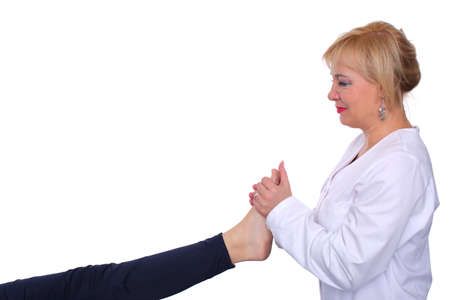 A physiotherapist performs a relaxing massage on the muscles of the upper part of the foot by...