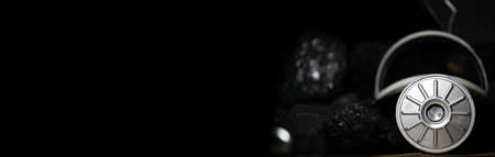 Dust mask with filter lies on black coal background for mine rescue workers. Panorama