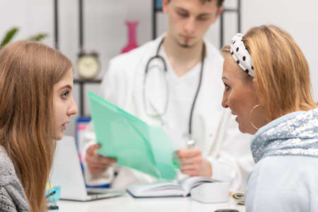 A mother and daughter are talking in a doctors office about an illness the doctor has pointed out....