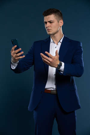 A businessman received a bad message on his cell phone. Disgruntled man.の写真素材