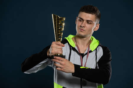 An athlete with a trophy in hand for winning first place in an event.の写真素材