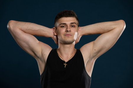 An athlete outside the bodybuilding waters shows off his muscles by flexing his arm muscles.の写真素材