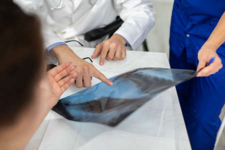 The doctors explain to the patient the reason she is experiencing pain in her lungs.の写真素材
