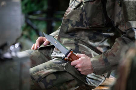A soldier in a moro uniform sits on a chair with a bayonet in his hand. Strong women in the military.の写真素材