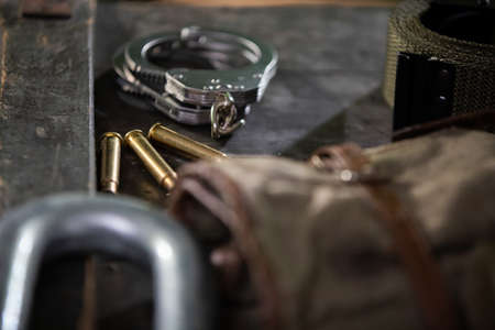 On the crate are eating handcuffs three empty rifle cartridges and a military belt.の写真素材