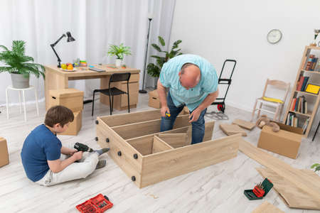 Dad is trying things on and seeing which screws to use. Assembling furniture.