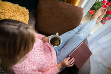 View from above as a girl holds a cup of coffee.の写真素材