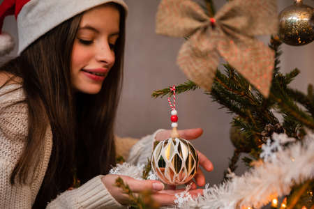 A Christmas tree bauble in a womans hands during Christmas.