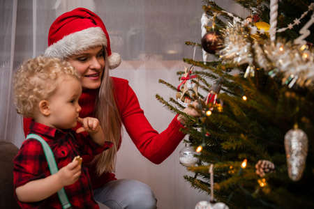 A mom tells her two-year-old son about the Christmas tree and Christmas dawns.の写真素材