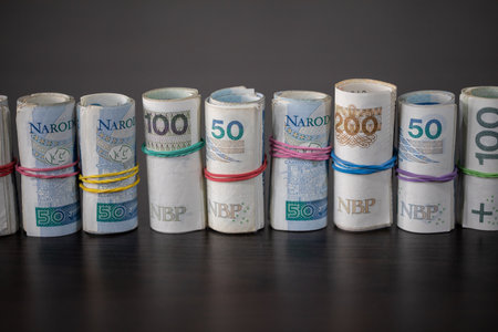 Banknotes rolled and tied together with a rubber band placed on a table.の写真素材