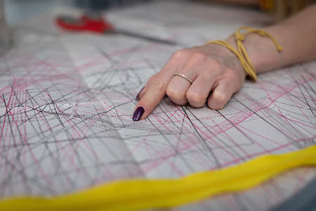 A clothing designer points out the details in a die-cut sheet.