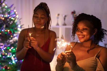 Two African women spend Christmas together and hold cold fires in their hands.の写真素材
