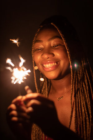 Full of happiness, the African woman holds burning cold fires in her hand.の写真素材