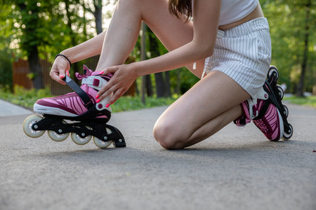 The woman kneels and buckles her rollers.の写真素材