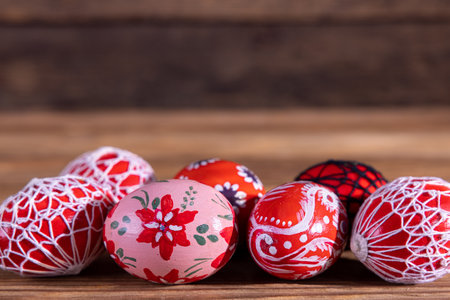 Easter eggs in shades of red arranged in a row on old boards.の写真素材
