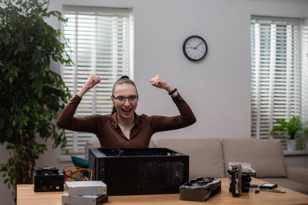 The woman sitting at the desk raises her hands in a gesture of victory.の写真素材