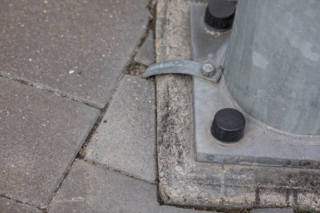 A metal lamp post attached to a concrete base.の写真素材
