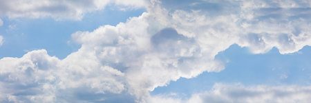 A panoramic view of the sky full of heavy clouds in white and gray.