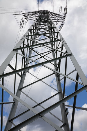 View from below of the tall poles of the high-voltage overhead line.の写真素材