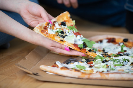 Close-up of a pizza with salami, olives, cheese and sauce.