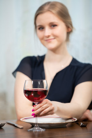 A smiling girl dressed festively sits at a table.の写真素材