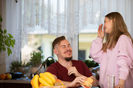 The happy couple spend the morning together in the kitchen over breakfast.の写真素材