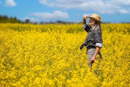 A Cheerful Woman Enjoying the Beauty of Nature in a Colorful Field Filled with Yellow Flowers