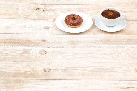 A delicious Coffee and Chocolate Donut beautifully presented on a Rustic Wooden Tableの写真素材