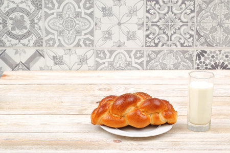 Freshly Baked Challah Served with a Glass of Milk on a Rustic Wooden Table Setting