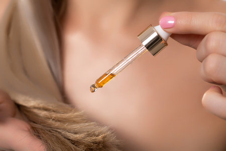 Discover the benefits of Hair Oil Dropper Application for achieving nourished and luxurious locksの写真素材