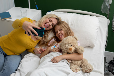 Joyful Moments at the Hospital Capturing a Fun Selfie of Mother and Her Child Togetherの写真素材