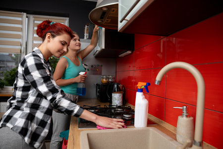 Two Friends Enjoy Cooking Together in a Stylish and Modern Kitchen Filled with Joyの写真素材