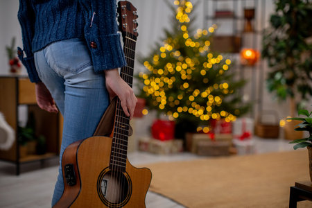 Enjoy a Cozy Holiday Atmosphere Featuring Soft Acoustic Guitar Music and a Beautiful Christmas Treeの写真素材