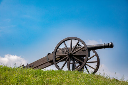 A Historic Cannon Situated on a Hill Under a Clear Blue Sky, Evoking Memories of the Pastの写真素材