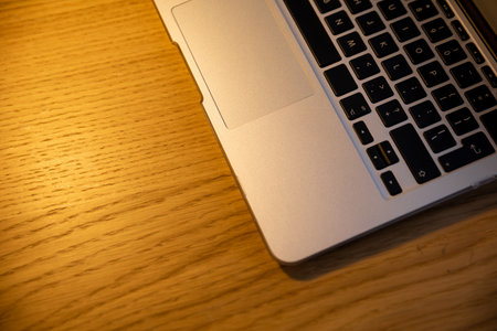 A modern laptop placed on a beautifully crafted wooden desk, creating a stylish workspace