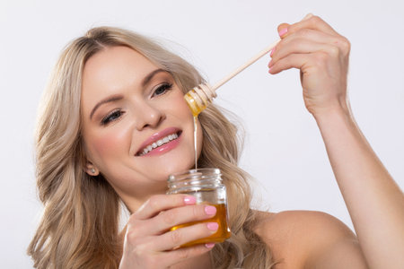 A Delicious Honey Drizzle is made even better with a Happy Smiling Woman enjoying itの写真素材