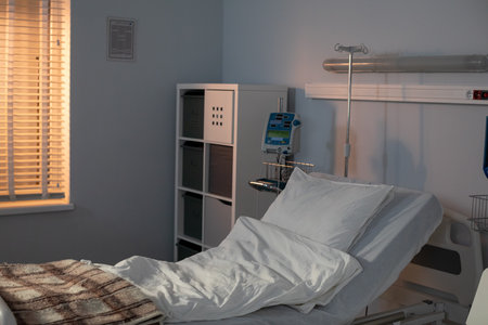 A contemporary hospital room equipped with an adjustable bed and generous natural light streams inの写真素材