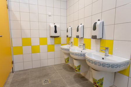 The public restroom is bright, clean, and features modern amenities for comfort and hygieneの写真素材