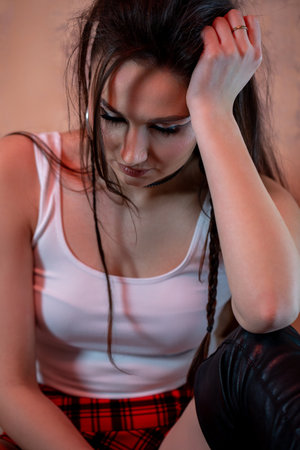 A Contemplative Young Woman in a Casual and Relaxed Setting, Evoking Deep Emotionsの写真素材